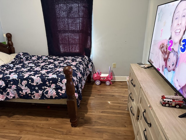 bedroom with baseboards and wood finished floors