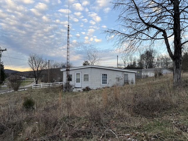 back of property at dusk with fence