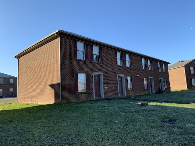 view of front of home with brick siding and a front yard