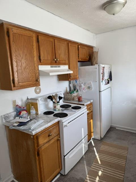 kitchen with under cabinet range hood, light countertops, brown cabinetry, electric range, and a textured ceiling