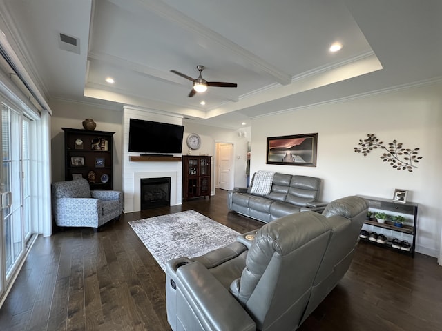 living room with visible vents, crown molding, a raised ceiling, and dark wood-type flooring