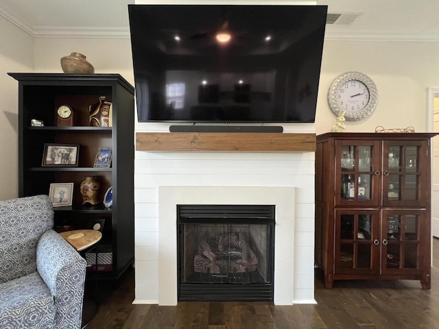 room details with a fireplace, wood finished floors, and ornamental molding