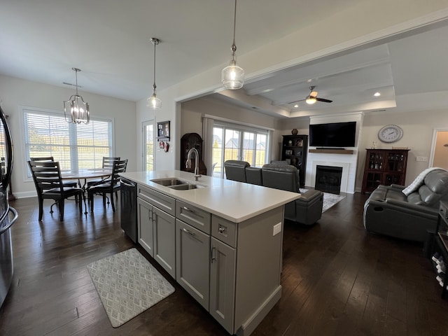 kitchen featuring a sink, black dishwasher, dark wood-style floors, a fireplace, and light countertops