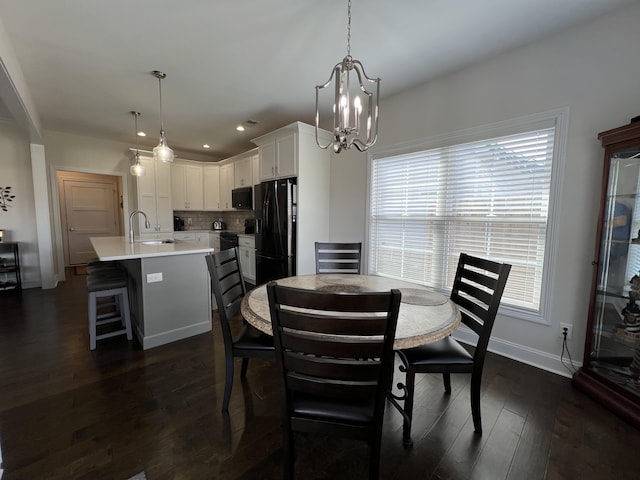 dining space featuring dark wood finished floors, recessed lighting, baseboards, and an inviting chandelier