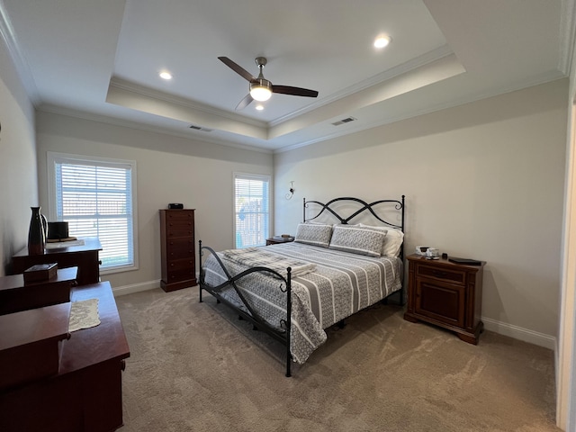 bedroom with visible vents, a raised ceiling, light colored carpet, and multiple windows