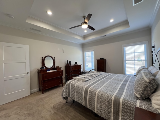 bedroom with a raised ceiling, multiple windows, and visible vents