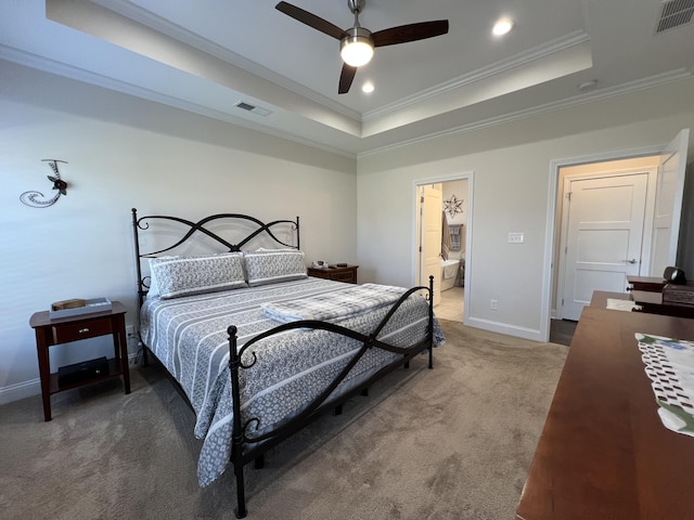 carpeted bedroom with a tray ceiling, crown molding, visible vents, and baseboards