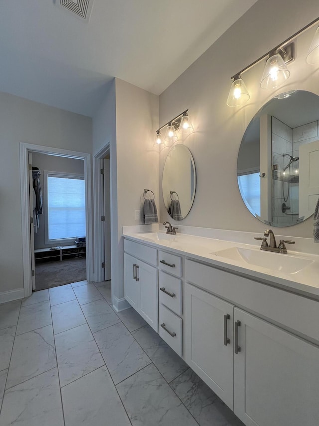 bathroom featuring a sink, visible vents, marble finish floor, and double vanity