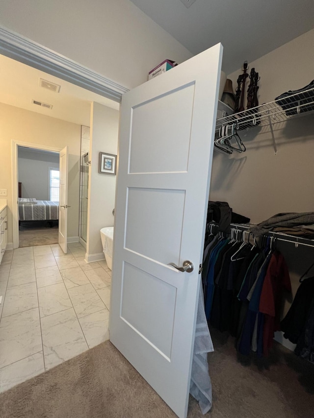 ensuite bathroom featuring a shower with door, visible vents, connected bathroom, a freestanding tub, and marble finish floor