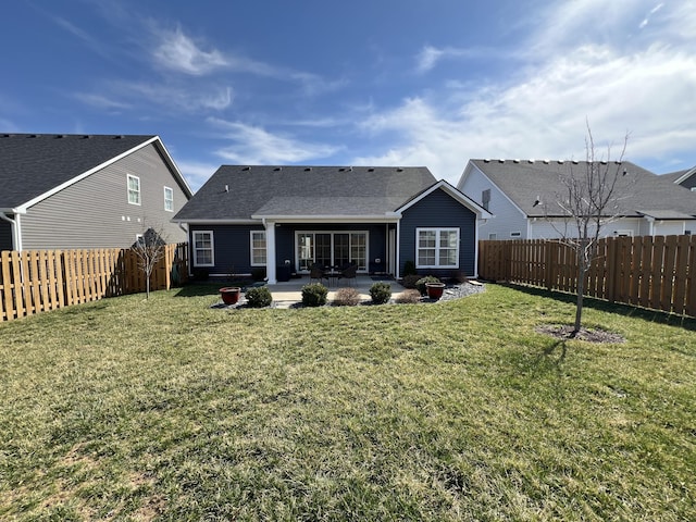 rear view of property featuring a fenced backyard, a lawn, and a patio