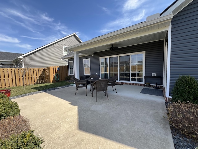 view of patio with outdoor dining area, ceiling fan, and fence