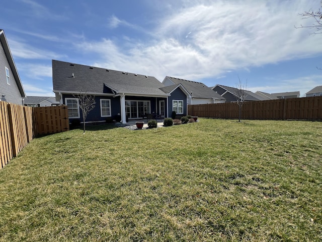 back of house featuring a fenced backyard and a yard