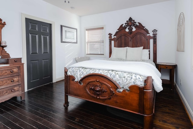 bedroom featuring dark wood-style floors and baseboards