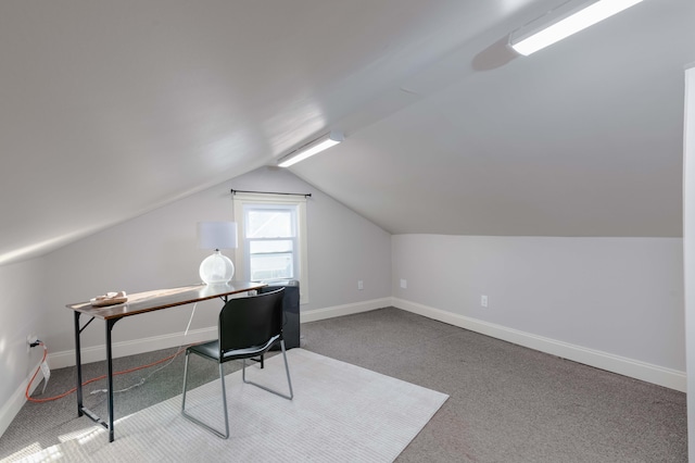 carpeted office featuring vaulted ceiling and baseboards