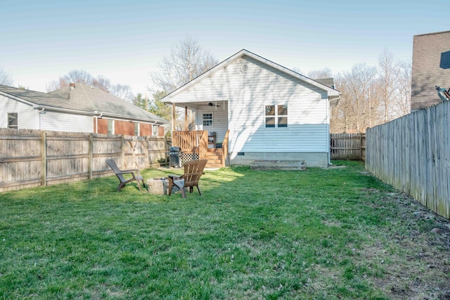 back of house featuring a lawn and a fenced backyard