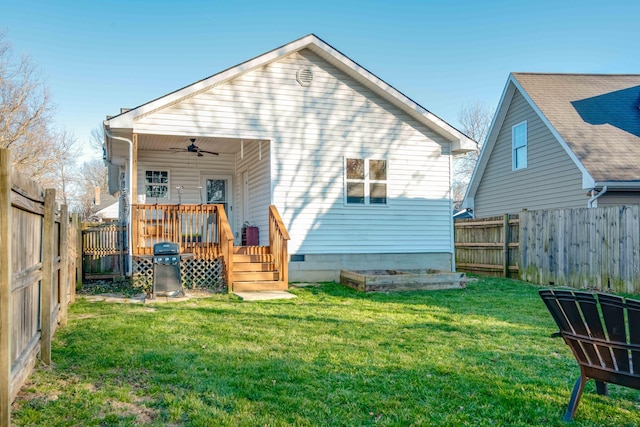 rear view of property with a yard, a fenced backyard, a wooden deck, and ceiling fan