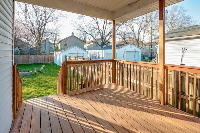 wooden deck featuring an outbuilding, a lawn, a residential view, and a fenced backyard