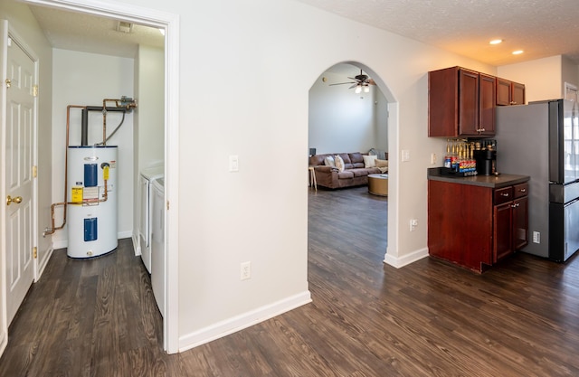 kitchen with a ceiling fan, dark wood finished floors, a textured ceiling, dark countertops, and electric water heater