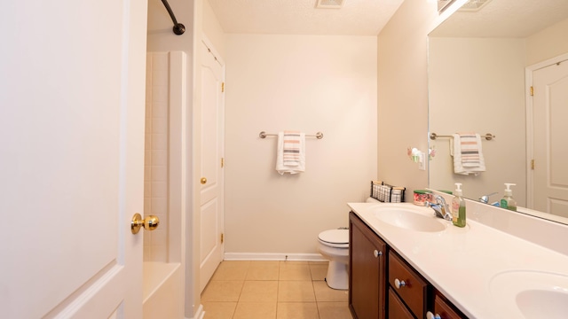 bathroom with baseboards, double vanity, a sink, tile patterned floors, and toilet