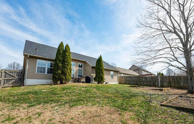 back of house with a lawn and a fenced backyard