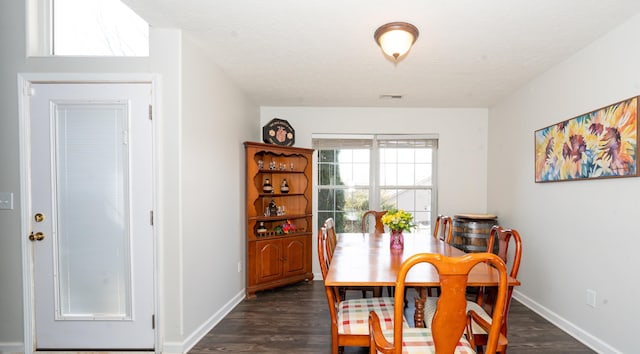 dining room with dark wood-type flooring, baseboards, visible vents, and a textured ceiling