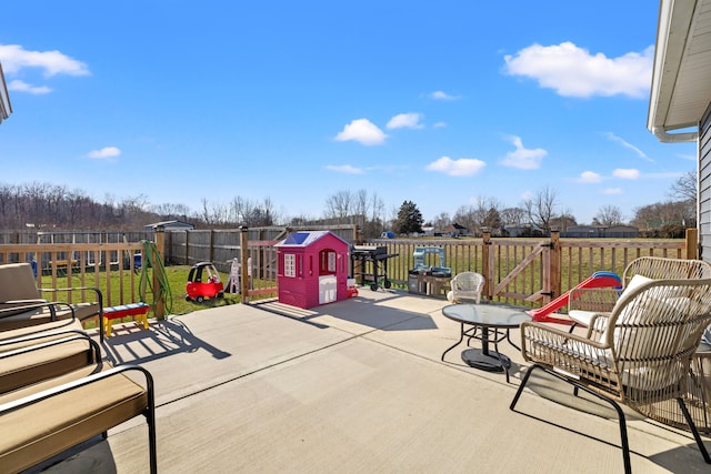 view of patio with a playground and a fenced backyard