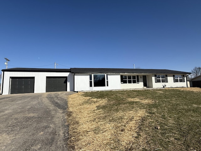 view of front of home featuring a front lawn, an attached garage, and driveway