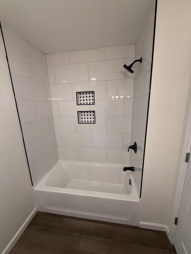 bathroom with shower / bath combination, baseboards, and wood finished floors