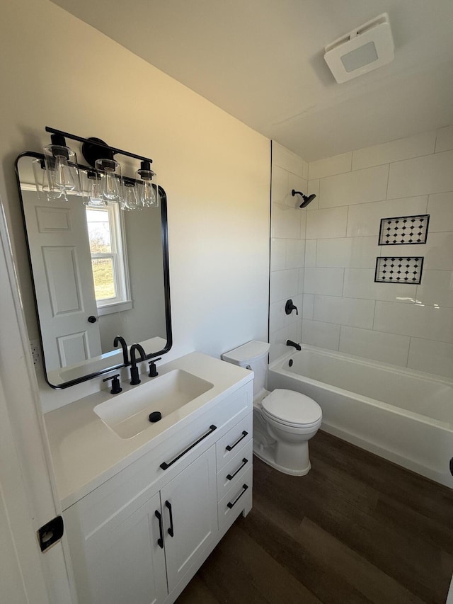 bathroom with shower / bath combination, toilet, wood finished floors, and vanity