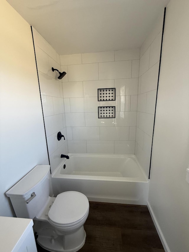 full bath with toilet, wood finished floors, tub / shower combination, baseboards, and vanity