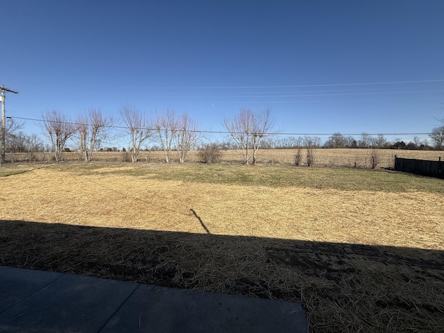 view of yard with a rural view and fence