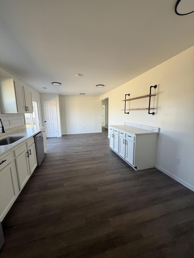 kitchen featuring dark wood-type flooring, a sink, white cabinets, decorative backsplash, and dishwasher