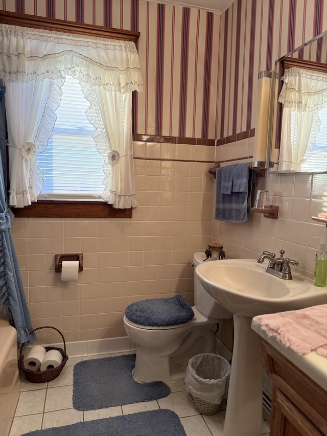 bathroom with tile patterned floors, a wainscoted wall, toilet, and wallpapered walls