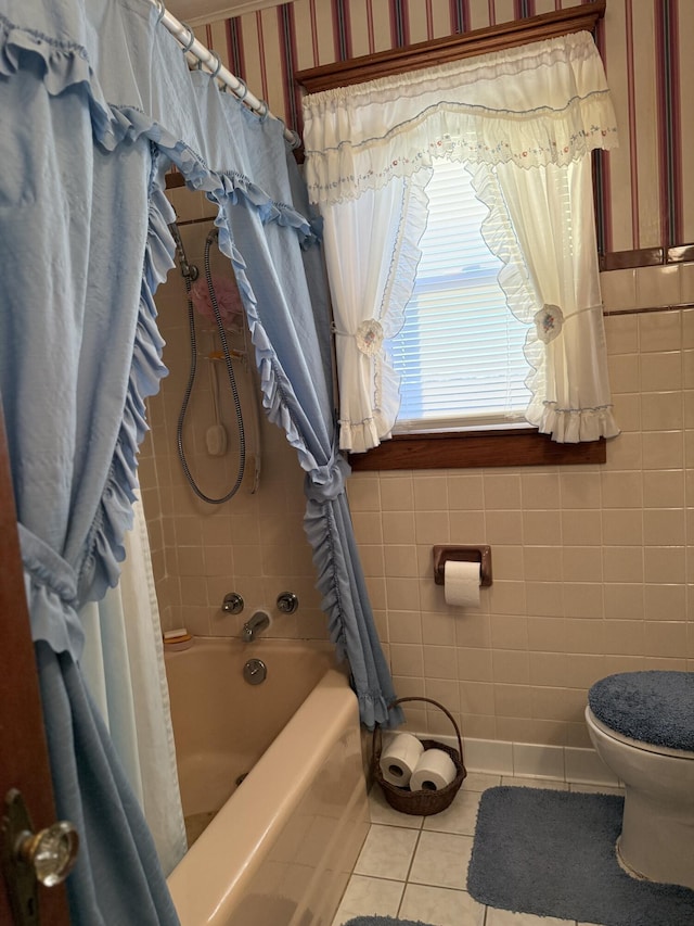 bathroom featuring tile patterned flooring, tile walls, toilet, and shower / bath combo