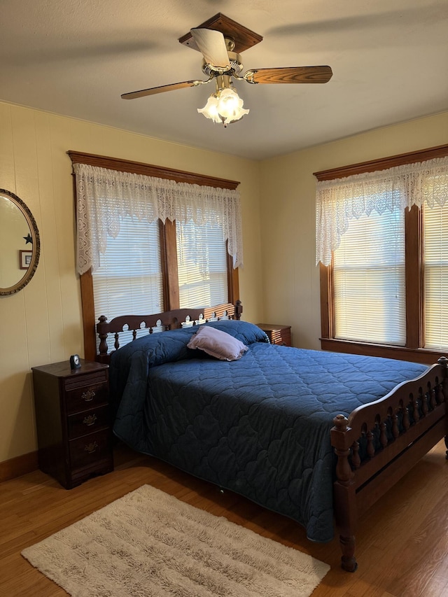 bedroom featuring baseboards, ceiling fan, and wood finished floors