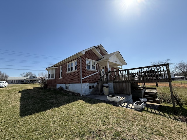 view of side of home featuring brick siding, stairway, a wooden deck, and a yard