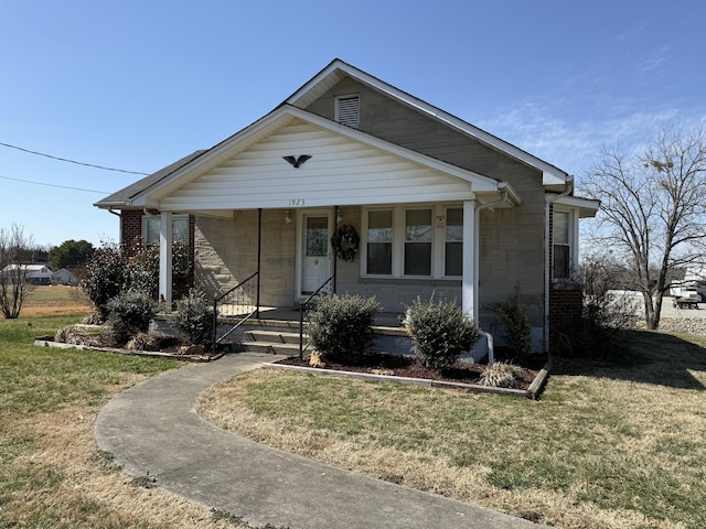 bungalow-style house featuring a front yard, a porch, and brick siding