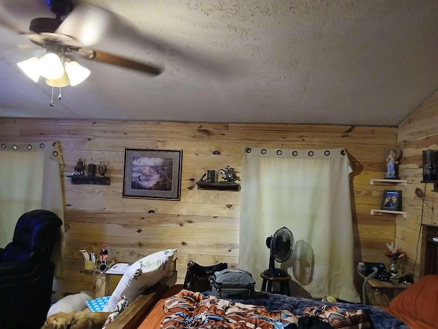 bedroom with ceiling fan, lofted ceiling, and wood walls