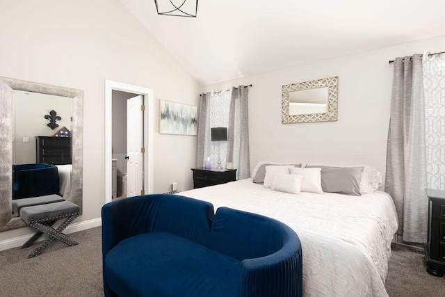 bedroom featuring baseboards, carpet floors, lofted ceiling, and ensuite bath