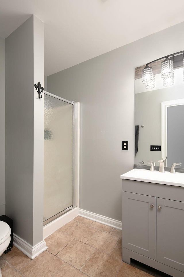 full bathroom featuring baseboards, a shower stall, vanity, and toilet