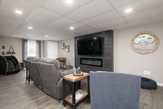 living area featuring recessed lighting, wood finished floors, and a paneled ceiling