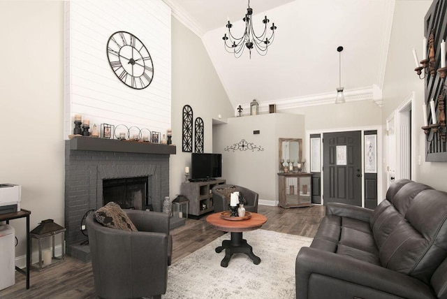 living room featuring baseboards, ornamental molding, an inviting chandelier, wood finished floors, and high vaulted ceiling