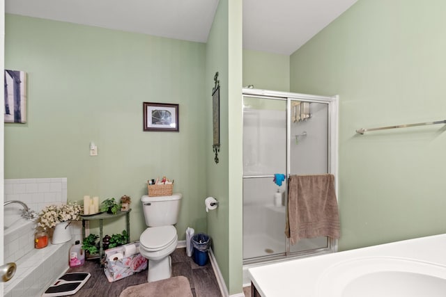 bathroom with a bath, baseboards, a stall shower, a sink, and toilet