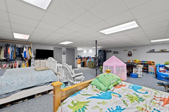 bedroom with a paneled ceiling and carpet floors