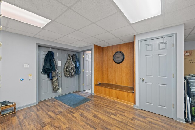 foyer with baseboards, a paneled ceiling, and wood finished floors