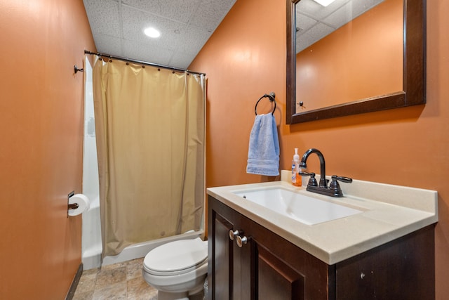 full bath with shower / bath combo with shower curtain, a paneled ceiling, toilet, and vanity