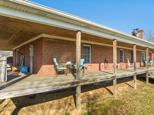 exterior space featuring covered porch and brick siding