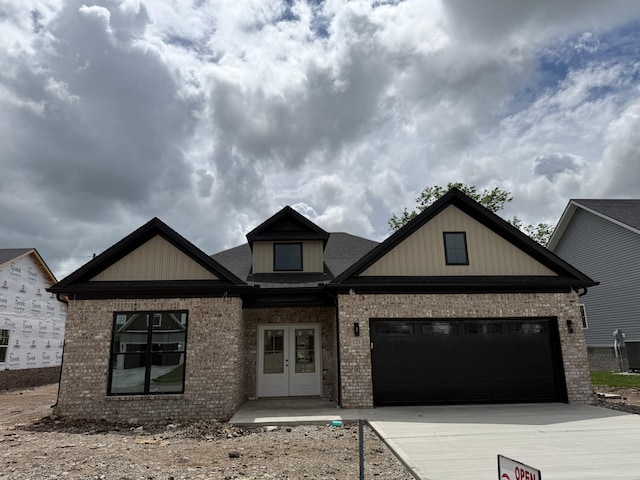 craftsman inspired home featuring a garage, french doors, brick siding, and driveway