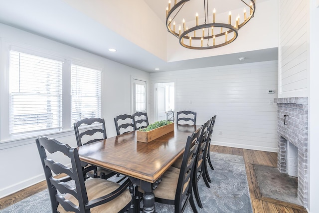 dining space featuring recessed lighting, baseboards, a brick fireplace, and dark wood finished floors