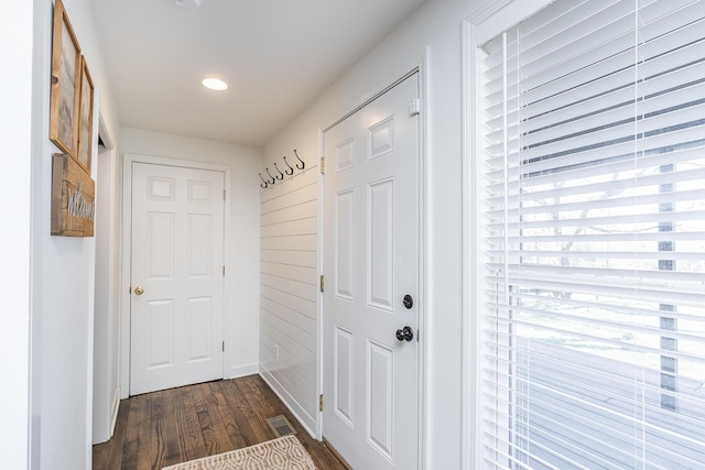 doorway to outside with visible vents, baseboards, and dark wood-type flooring